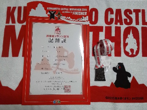 赤だらけで分かりにくいかもしれませんが,フィニッシャータオルと記録証,完走メダルです.記録証を入れるケースももらえます.メダルの形は,熊本城の石垣なので武者返しも分かりますかね? Tシャツは,まだ手にしていない人がおられるので,あえてアップしませんでしたが,背中に大きく「挑(いどめ)」の筆文字が入っています.でもつい「桃」に見えてしまう気がするのは私だけ・・・