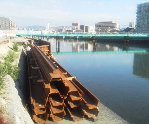 これは,猿候川東大橋の架け替え工事の進捗状況です.青い仮設橋の手前にあった旧橋脚がすっかりなくなり,鋼矢板がずらっと控えています.