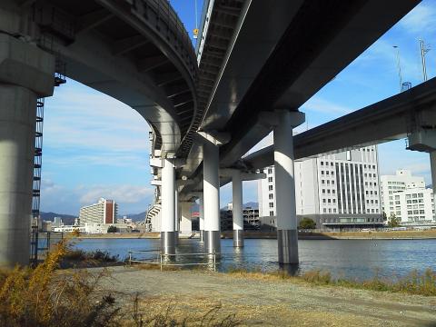 猿候川を渡って頭上にそびえるのは，広島高速２号線です．川向こう右手の建物はMツダの技術３号館．ある意味で全社の中枢です．