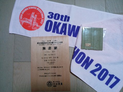 この完走証、やけに茶色っぽいのはわかりますか？　これは、家具や木工の街大川市の大会ということで、紙ではなくて薄い木なんですよ。これが欲しかったんです。フィニッシャータオルのイラストは筑後川昇開橋、船を通すために橋の一部が昇降します。大会の後で、動くところを見てきました。